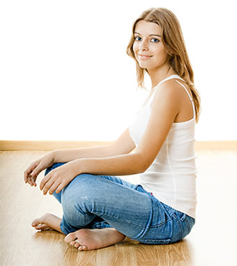 An attractive woman sitting on warm floor.