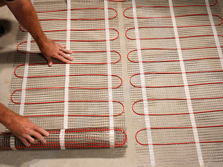 ComfortTile floor heating mat being installed.